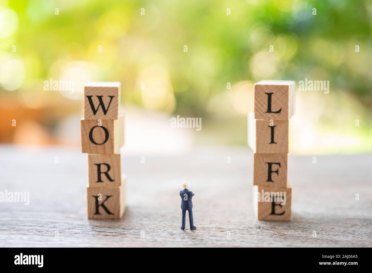 Miniature people businessmen standing with wood word WORK and LIFE ...