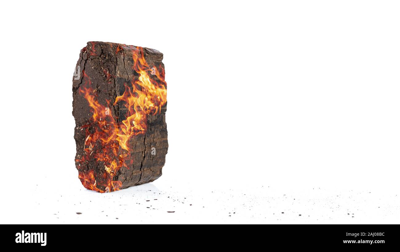 Peat briquette on fire. Alternative fuels theme. Wide banner with copy