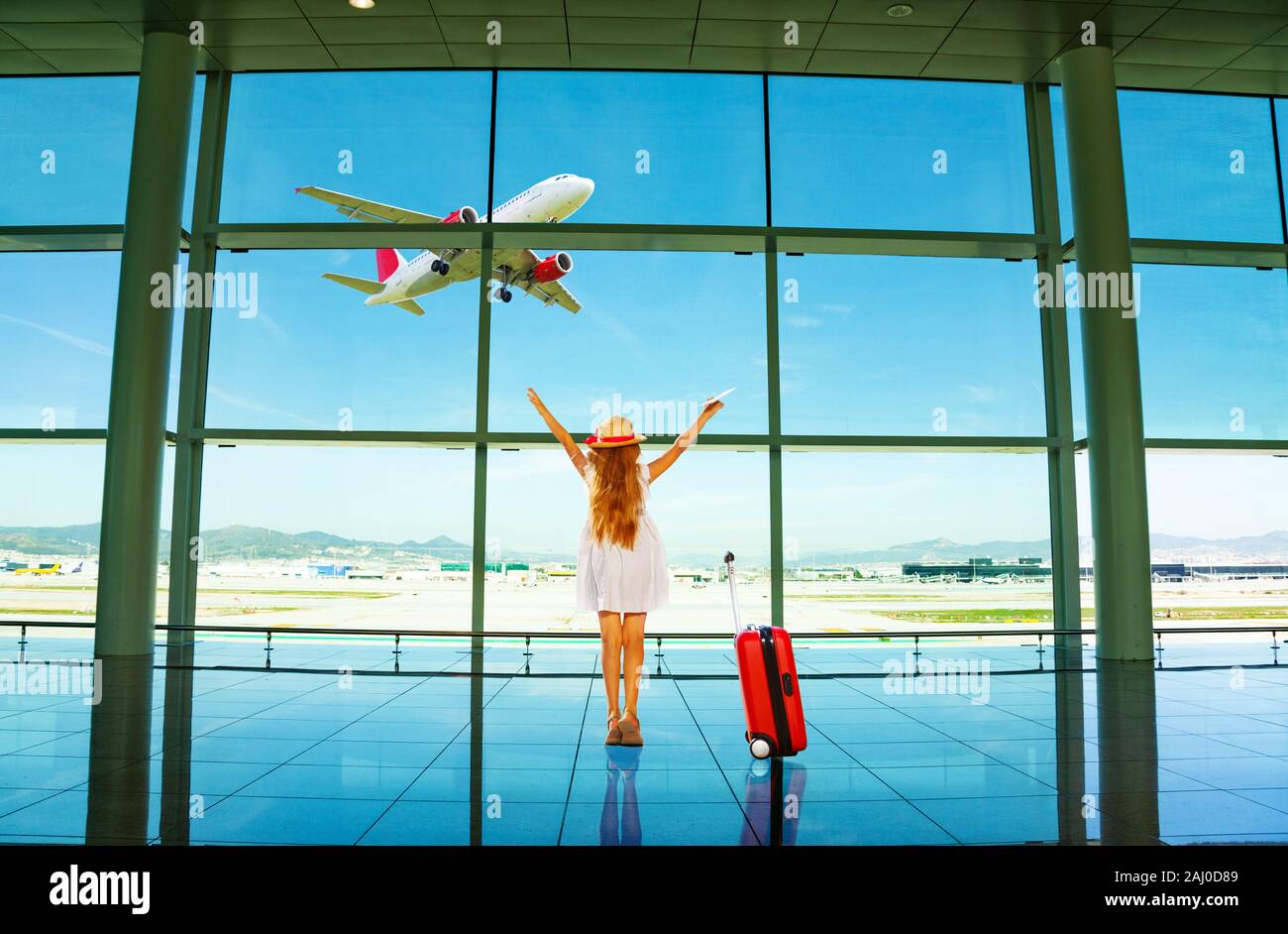 Girl with suit case stand in the hall of airport Stock Photo