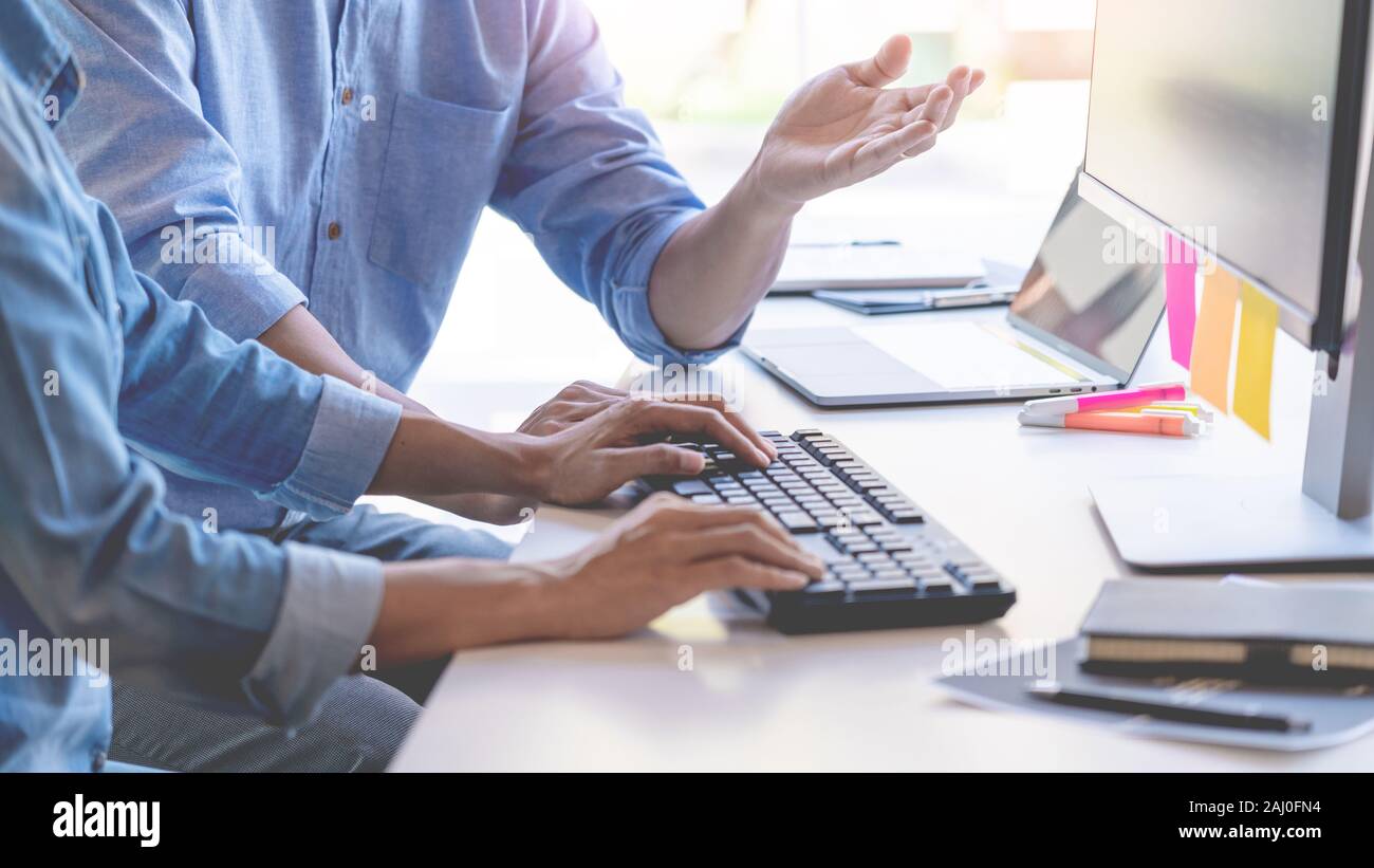 Young startup Programmers Sitting At Desks Working On Computers screen for Developing programming and coding to find solution to problem on New Applic Stock Photo