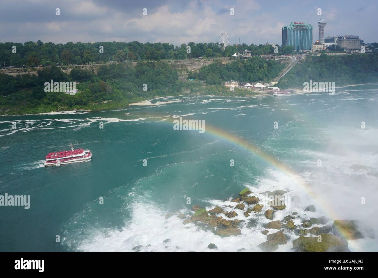 Niagara Falls, NY: A rainbow emerges from the mist as a tour boat sails through the Niagara Gorge. Stock Photo