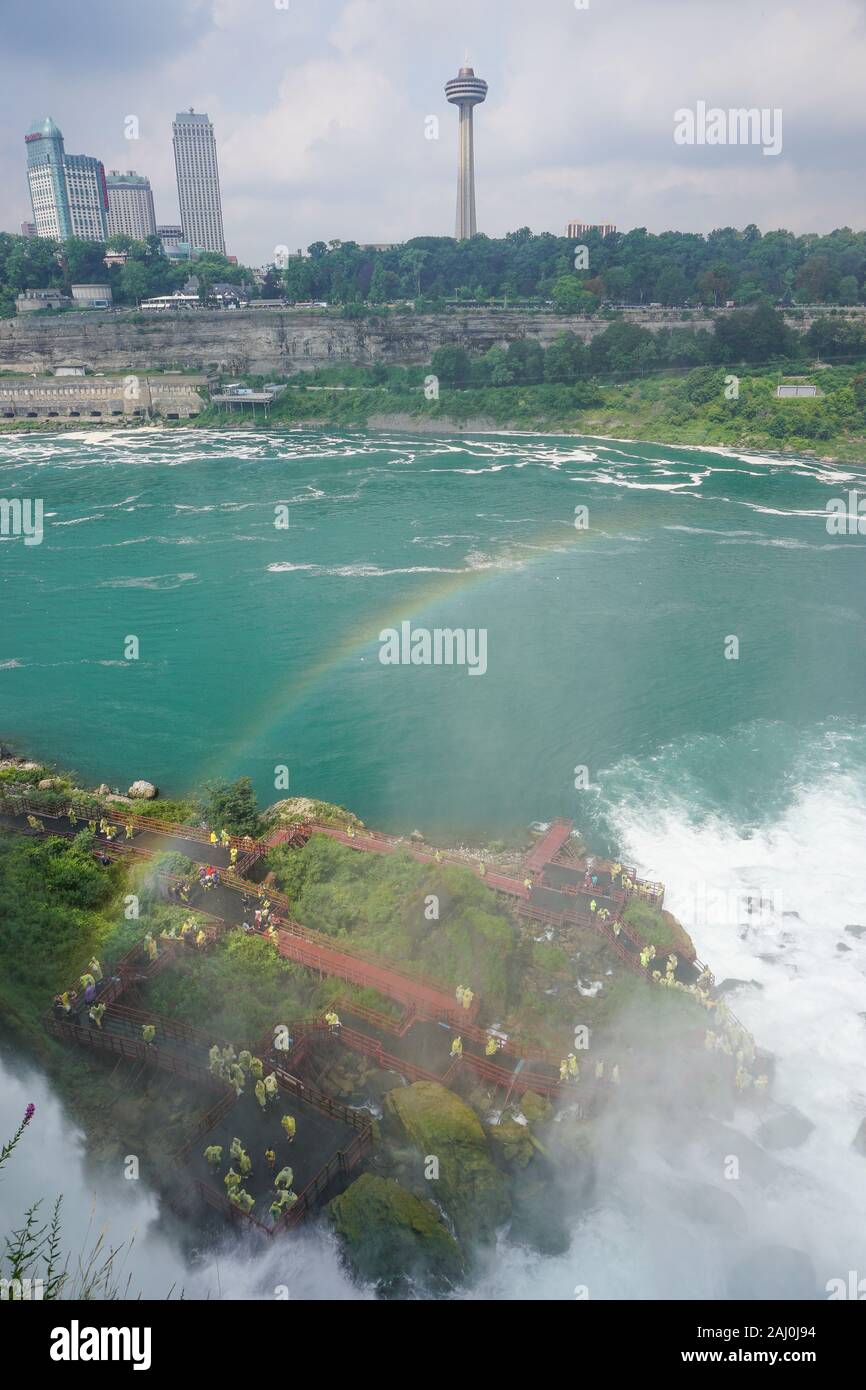Niagara Falls, NY: A rainbow emerges from the mist over tourists at the Cave of the Winds. Stock Photo