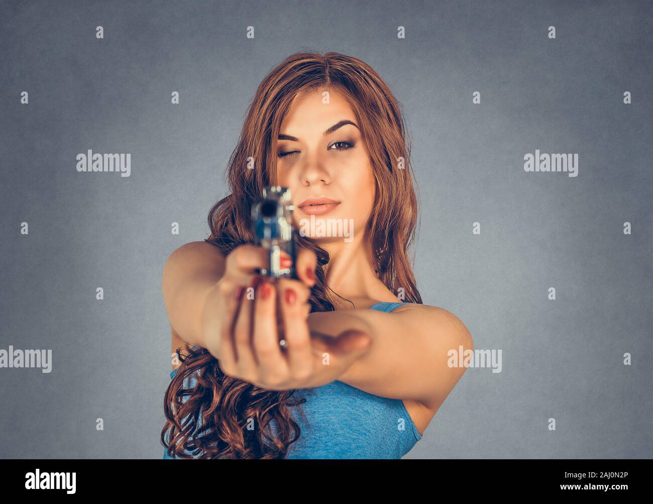 A hand holding gun and pointing it at camera hires stock photography