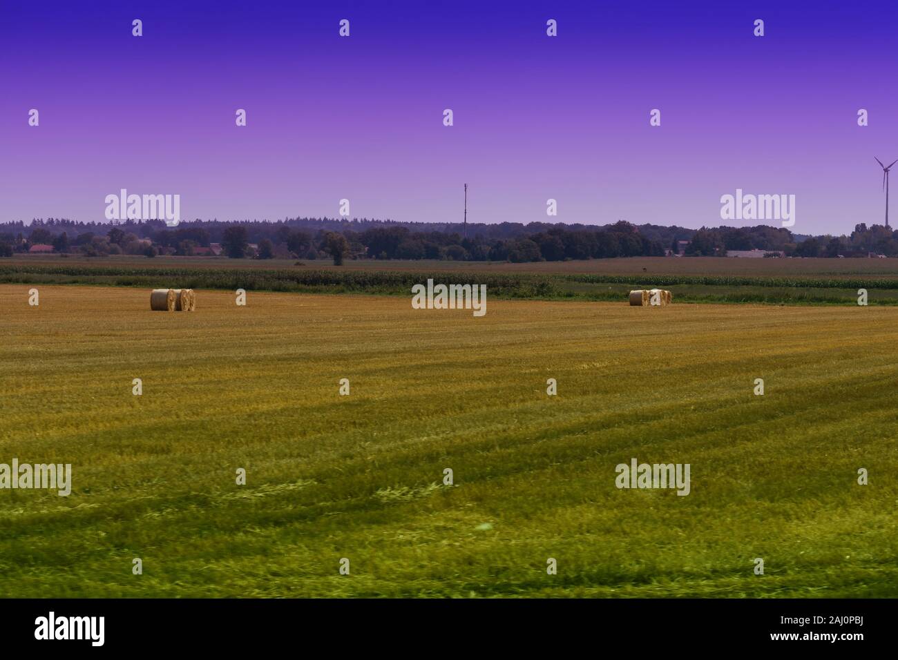 Straw bales on farmland with blue cloudy sky Stock Photo - Alamy