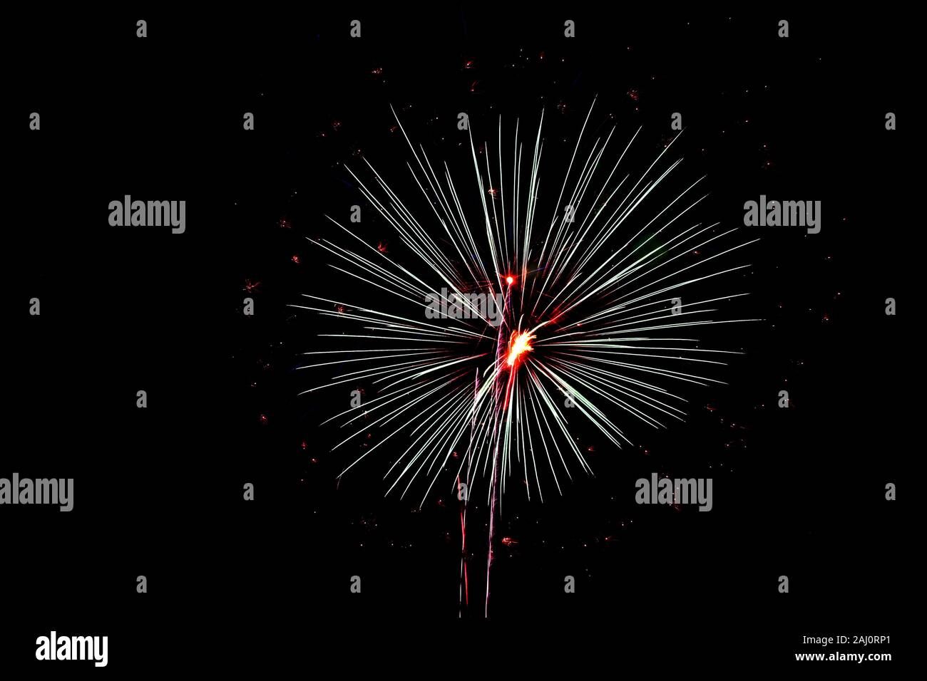 Red and white fireworks explode in the sky on the 4th of July Stock