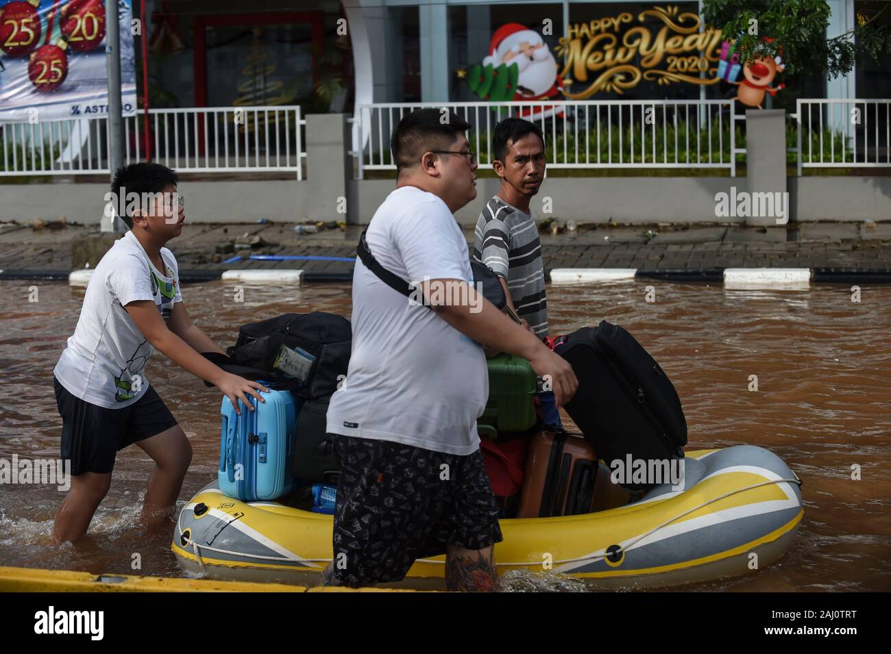 Jakarta, Indonesia. 2nd Jan, 2020. People transfer their belongings by rubber boat as they wade through a flooded street in Jakarta, Indonesia, Jan. 2, 2020. In Jakarta, evacuation of the flood-affected persons persisted as waters still submerged several parts of the city, and six people were reported dead in the city, said M. Ridwan, spokesman for a disaster agency in Jakarta. Credit: Agung Kuncahya B./Xinhua/Alamy Live News Stock Photo