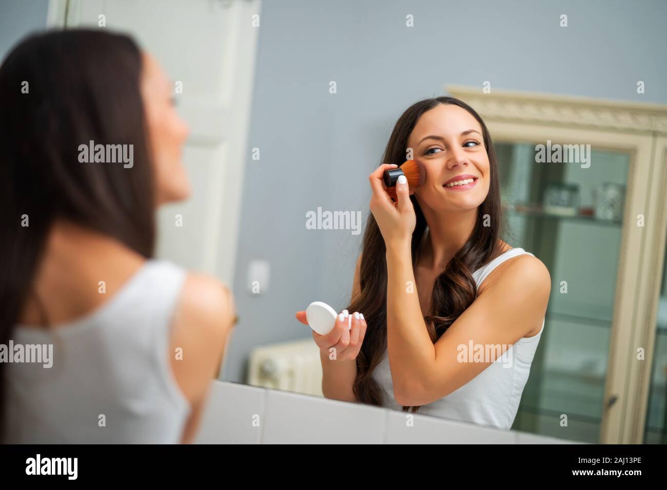 Woman looking mirror in washroom hi-res stock photography and images ...