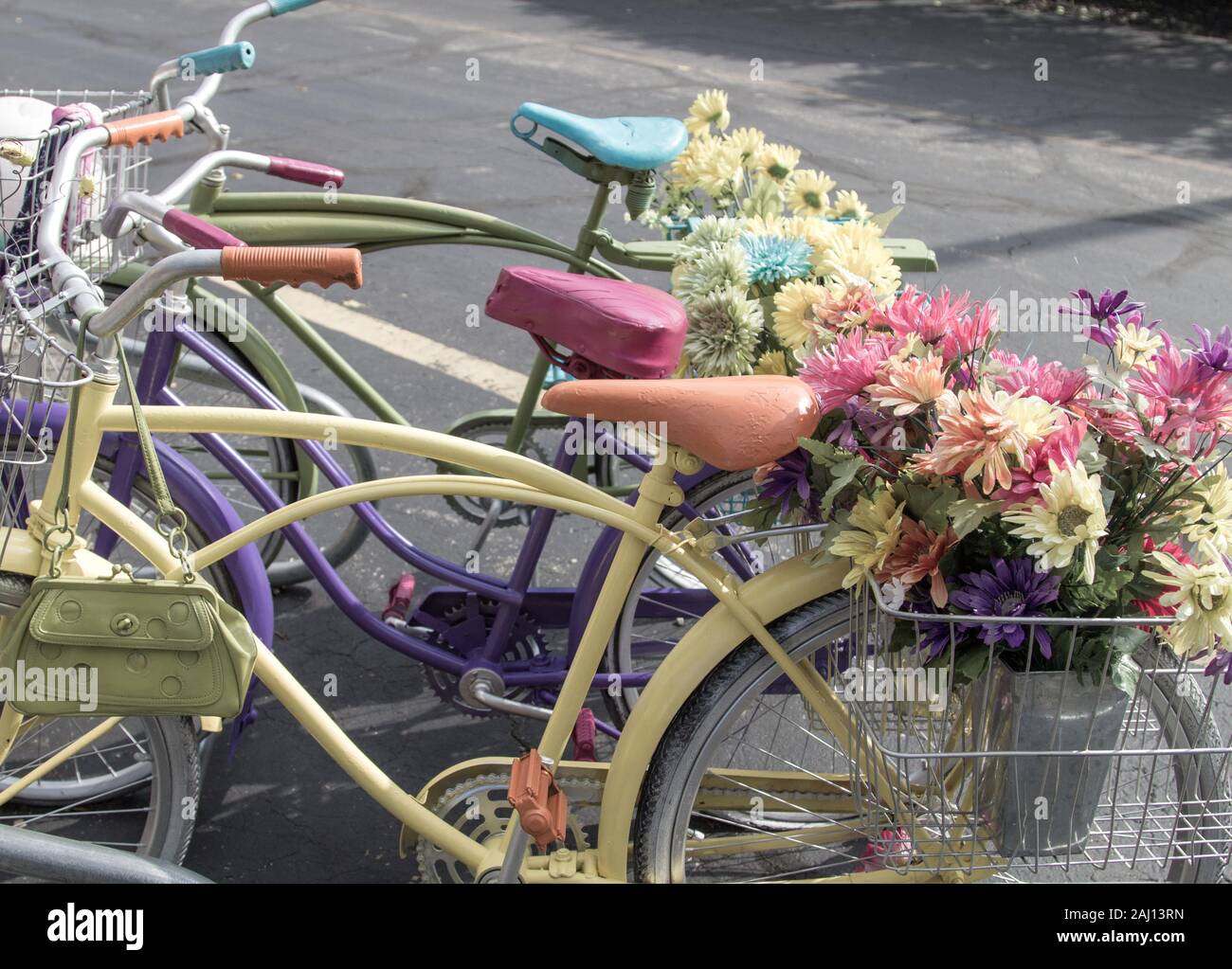 Row Of Retro Bicycles. Pastel colored vintage bicycles with flowers in basket. Stock Photo