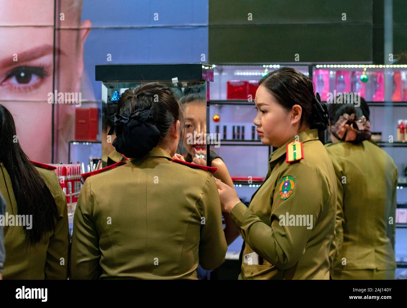 Young uniform military women testing make-up products in a specialized store Stock Photo