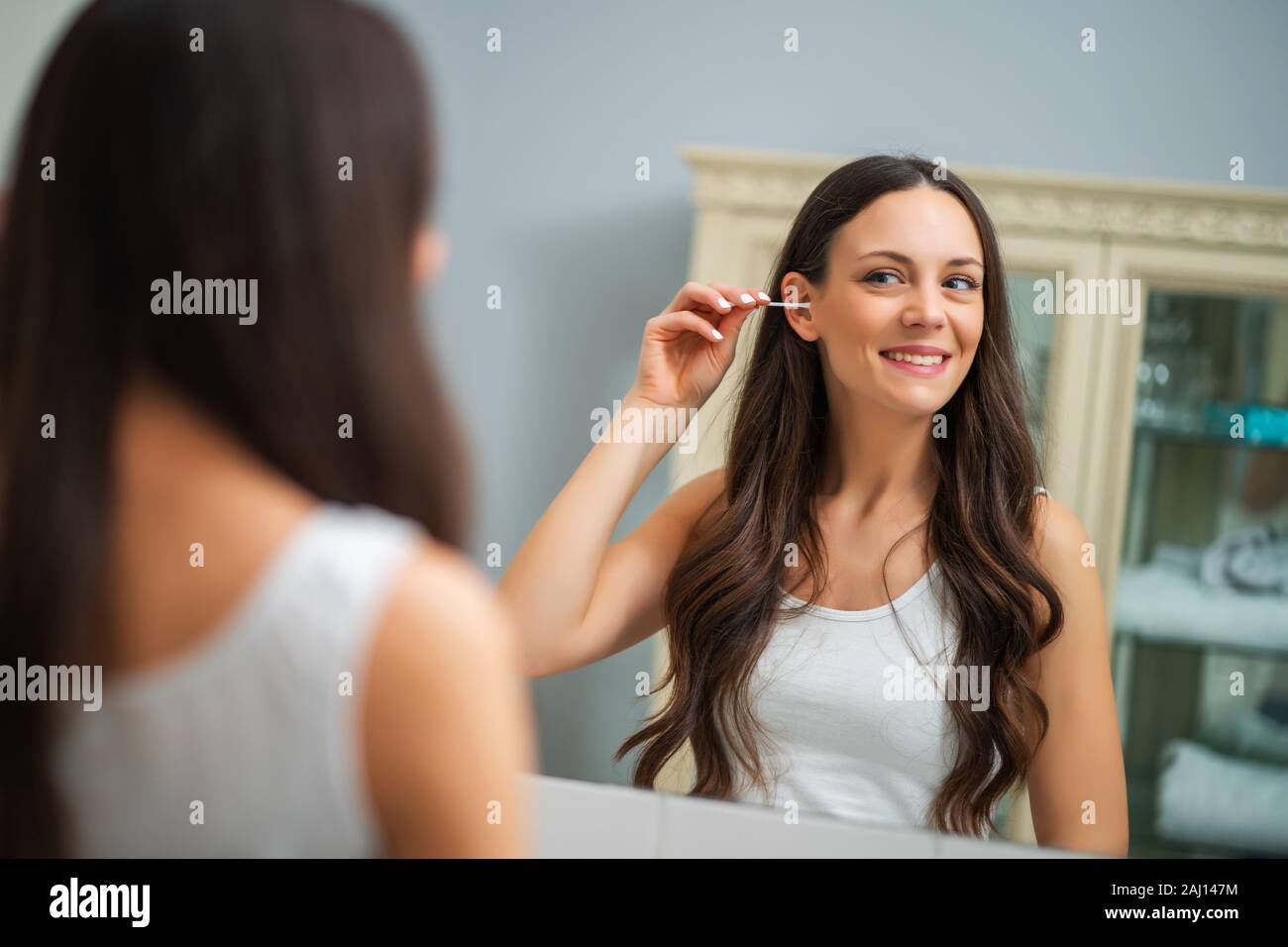 Young woman is cleaning ears in the bathroom Stock Photo Alamy