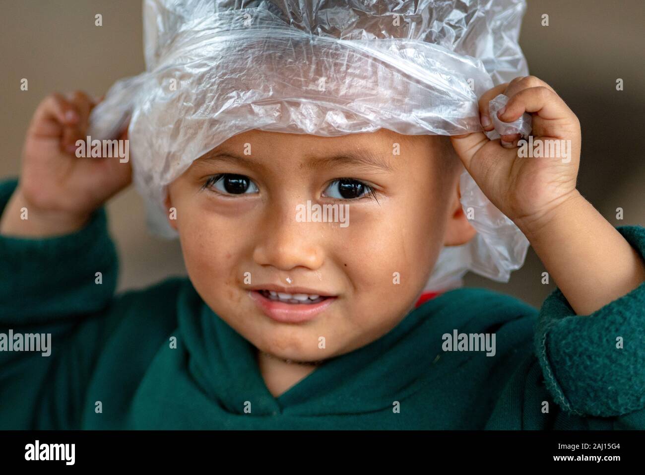 A young child plays with a plastic bag at the risk of loss Stock Photo