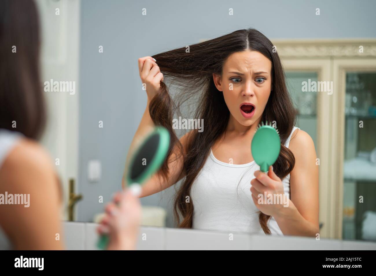 Young woman is in panic because of hair loss. Stock Photo