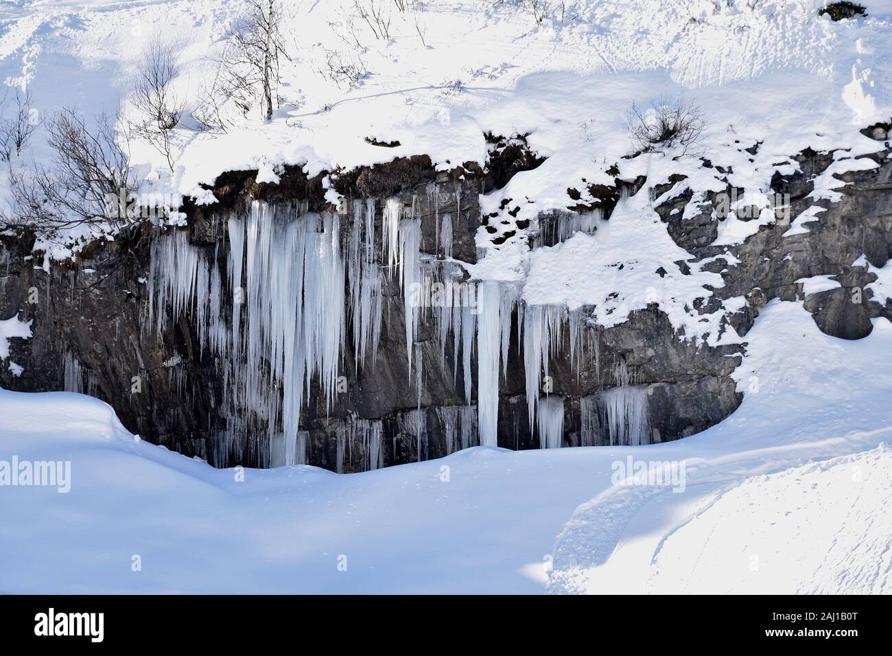 Herrliche Eiszapfen begrenzen eine Höhle im Schnee Stock Photo