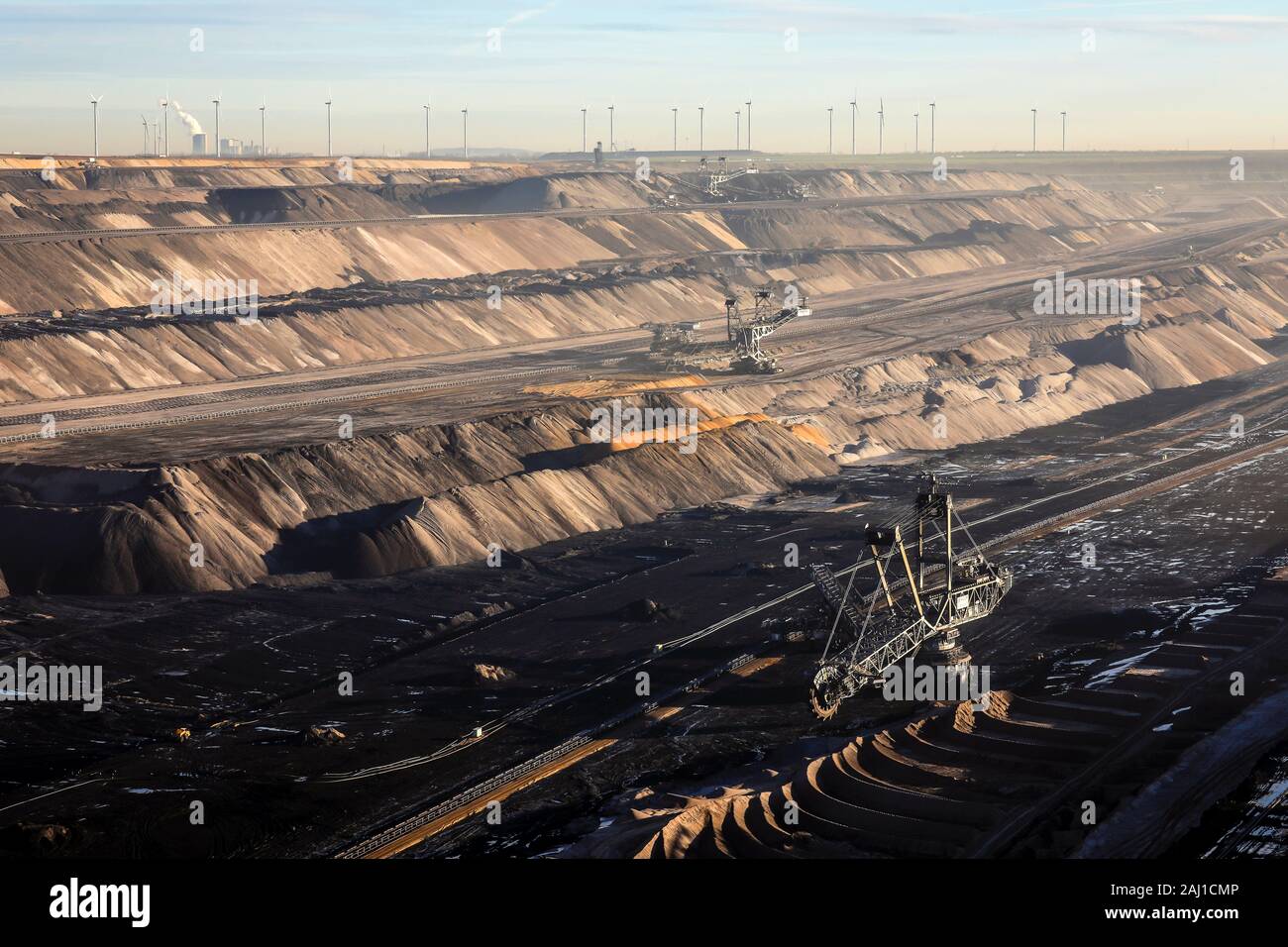 Juechen, North Rhine-Westphalia, Germany - Bucket wheel excavator in the RWE opencast lignite mine Garzweiler, Rhenish lignite mining area. Wind turbi Stock Photo