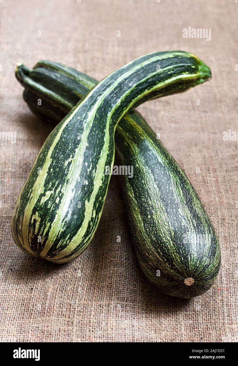 Fresh striped zucchini on sackcloth background Stock Photo