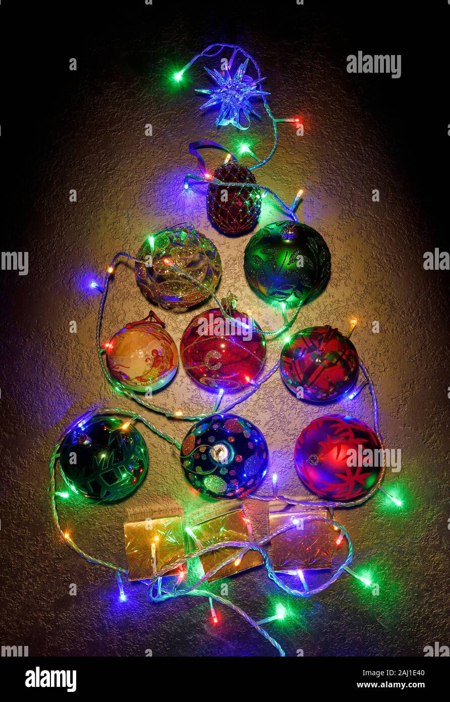 Overhead flat lay of a Christmas tree shape made up from baubles and fairy lights Stock Photo