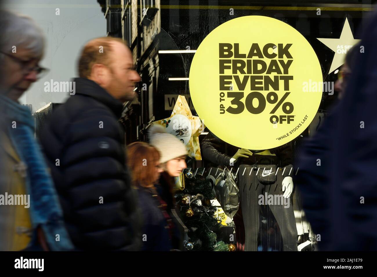 Shoppers walking past signs for Black Friday Sales in Chester city centre UK Stock Photo
