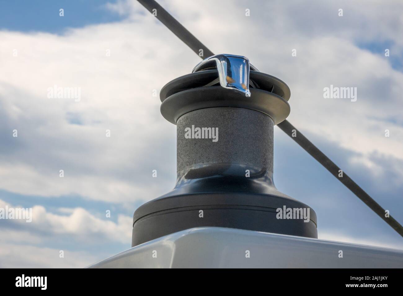 Yacht winch close-up on a background of blurry blue sky with clouds Stock Photo