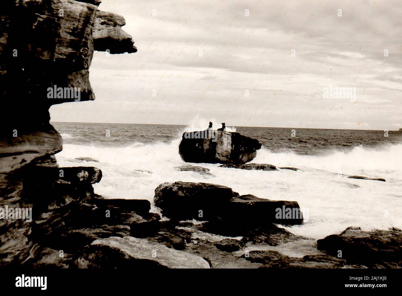 July 1971 - Mermaid rock, Bondi Beach, Australia,(when the mermaids were still intact). The rock (235 tons) itself was allegedly washed ashore during a storm on 15th July 1912. The mermaids were created by sculptor Lyall Randolph (installed 3 April 1960) were modelled on two local women  Jan Carmody, (Miss Australia Surf 1959) and Lynette Whillier, (champion swimmer and runner-up in the same contest.). Lynette was lost to the sea in 1974, the other with one arm missing was removed in 1976 and is preserved in Waverley library. Both were made from bronze coloured fiberglass. Stock Photo