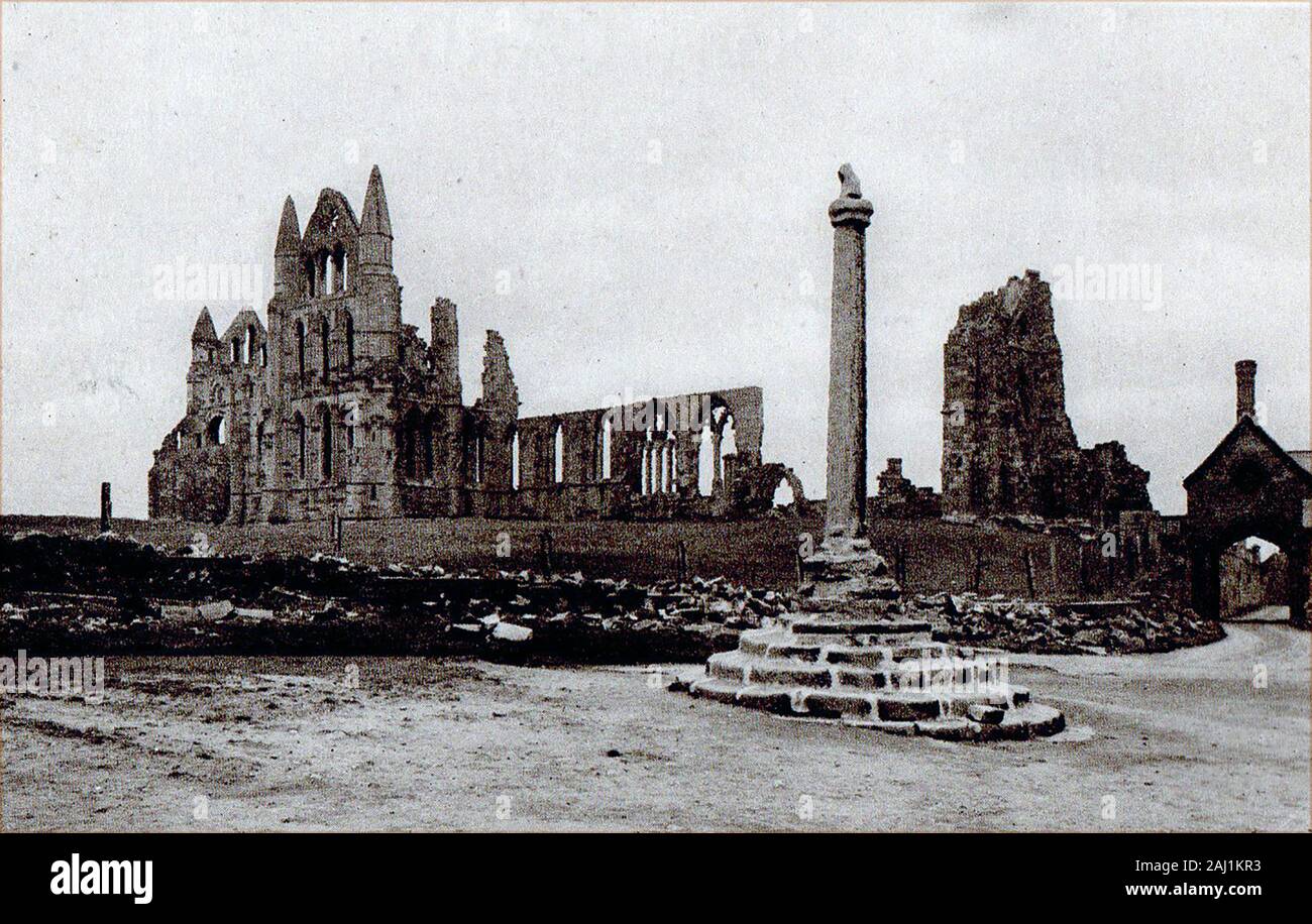 An historic, Circa 1905 photograph of Whitby Abbey (before the high wall was built around it, showing the arched entrance to Abbey House (Whitby Hall) , its courtyard and the abbey plain cross. Stock Photo