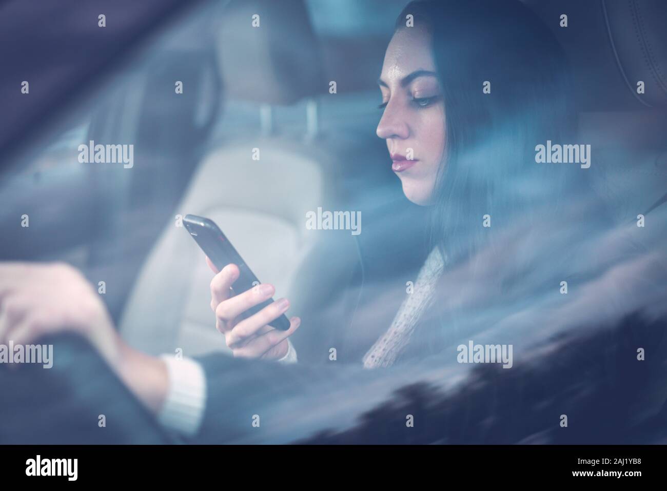 Beautiful young millennial woman texting and driving Stock Photo