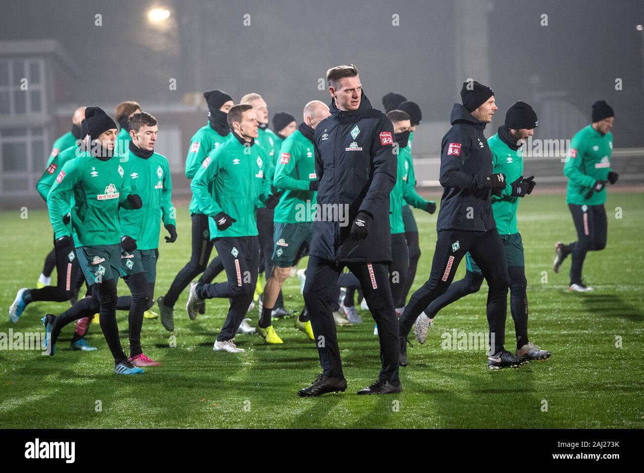 Bremen, Germany. 02nd Jan, 2020. Football: Bundesliga, training kick-off SV Werder Bremen. Tim Borowski (in front), assistant coach of Werder Bremen, passes the players running across the pitch. Credit: Sina Schuldt/dpa - IMPORTANT NOTE: In accordance with the regulations of the DFL Deutsche Fußball Liga and the DFB Deutscher Fußball-Bund, it is prohibited to exploit or have exploited in the stadium and/or from the game taken photographs in the form of sequence images and/or video-like photo series./dpa/Alamy Live News Stock Photo