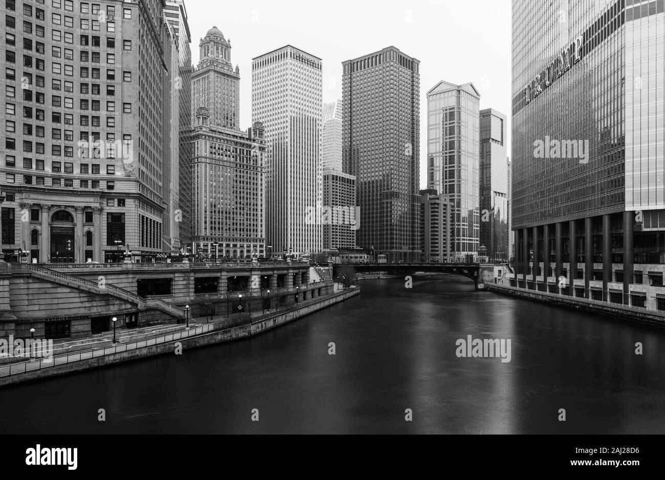 Chicago - March 2017, IL, USA: Black and white photo of Chicago downtown with skyscrapers, hotels, promenade and river viewed from the bridge Stock Photo