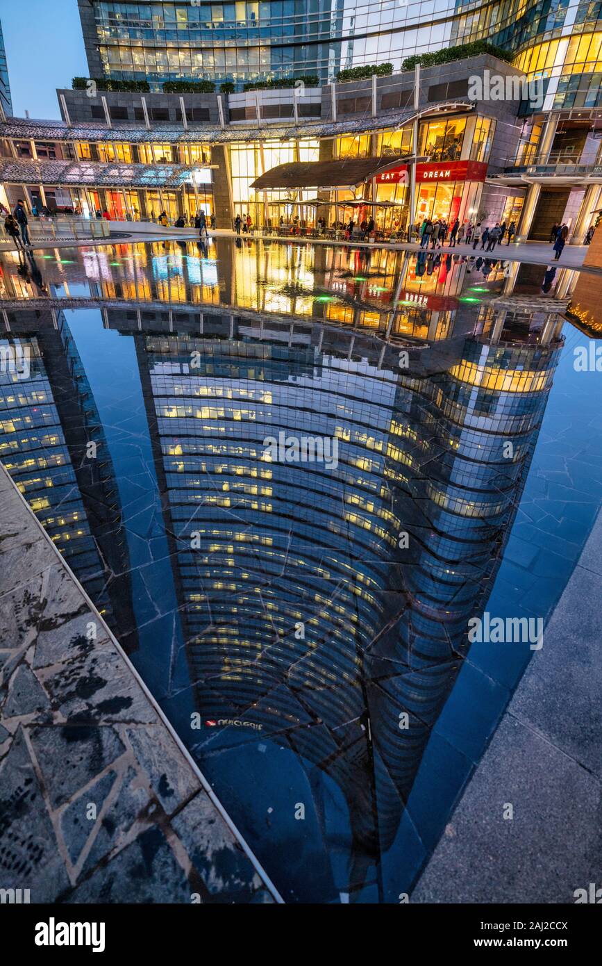 Milan Italy, Porta Nuova District. Gae Aulenti Square. Unicredit Tower reflected in a puddle Stock Photo