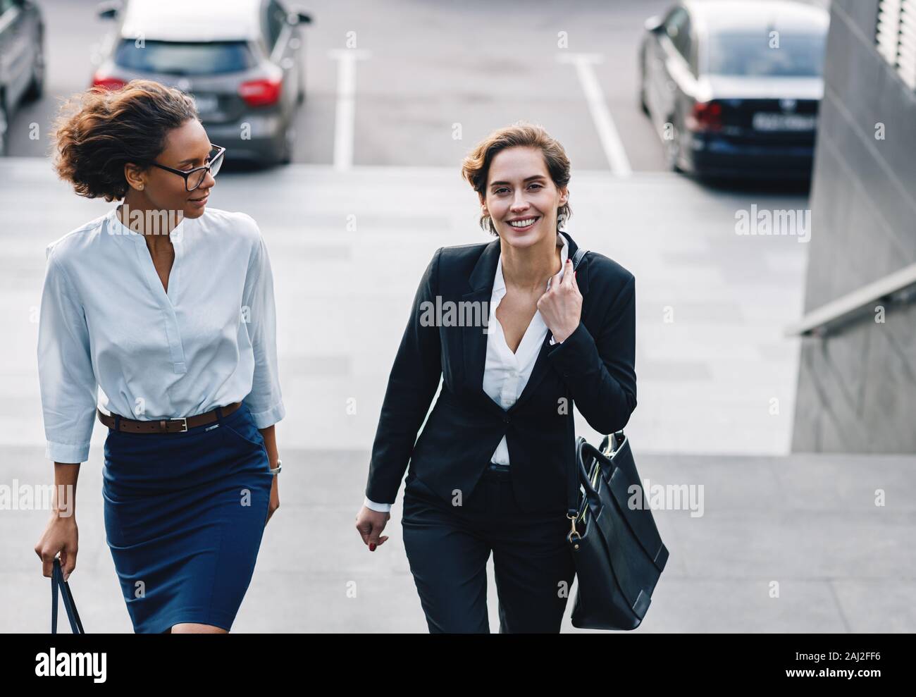 Two People Getting Steps In Two business people walking up the steps outdoors Stock Photo - Alamy