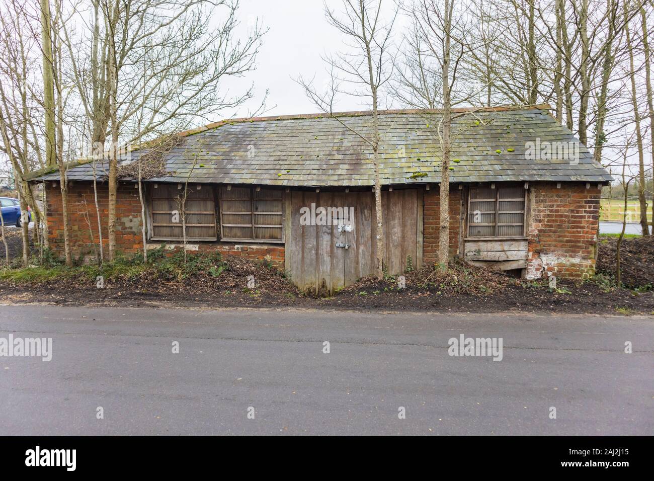 Small disused backsmith's smithy, a neglected roadside historic building in disrepair in Nursling near Southampton, Hampshire, southern England Stock Photo