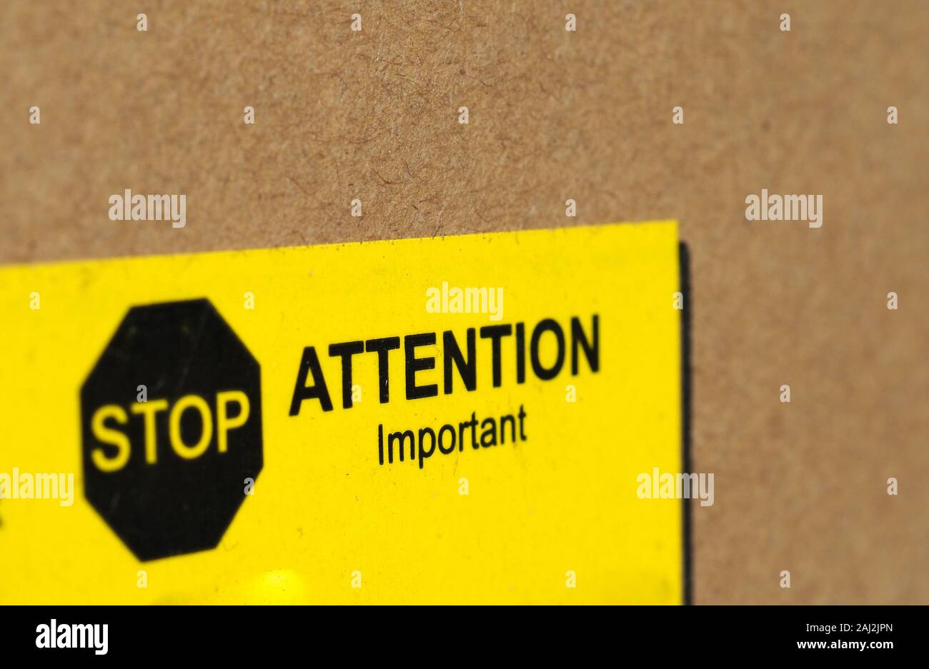 stop attention important warning sign in black and yellow on packet Stock Photo