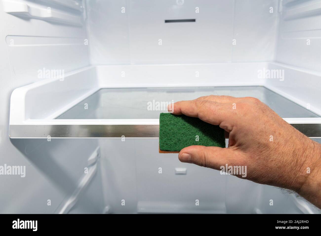 Hand cleaning inside of refrigerator. Stock Photo