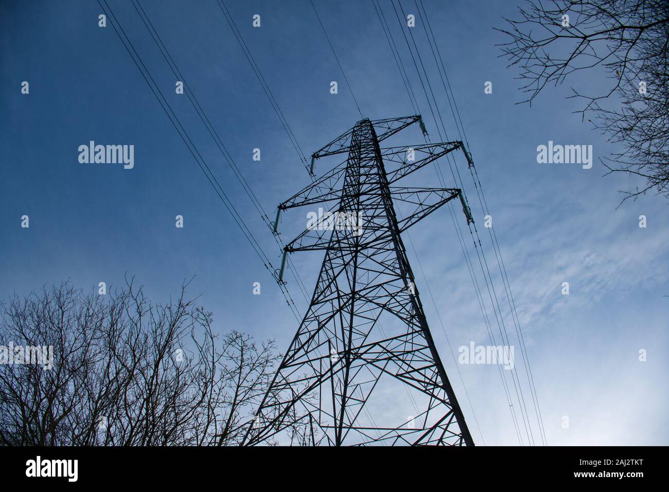 A high voltage electricity transmission pylon in winter - part of the national grid for the distribution of power by overhead cables in the UK. Stock Photo