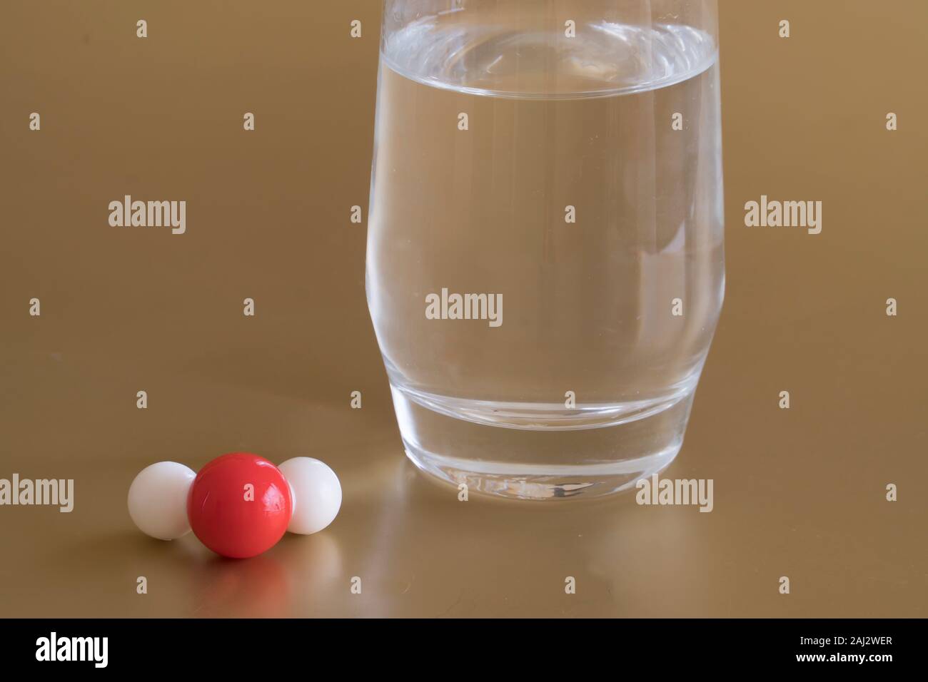 Glass of liquid water and the H2O molecule with one hydrogen and two oxygen atoms . Stock Photo