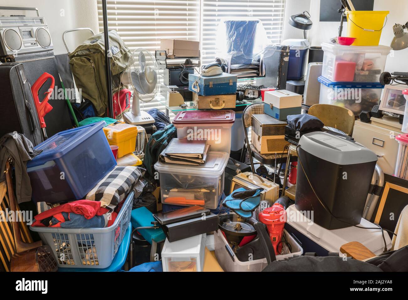 Hoarder room packed with boxes, electronics, business equipment, household objects and miscellaneous junk. Stock Photo
