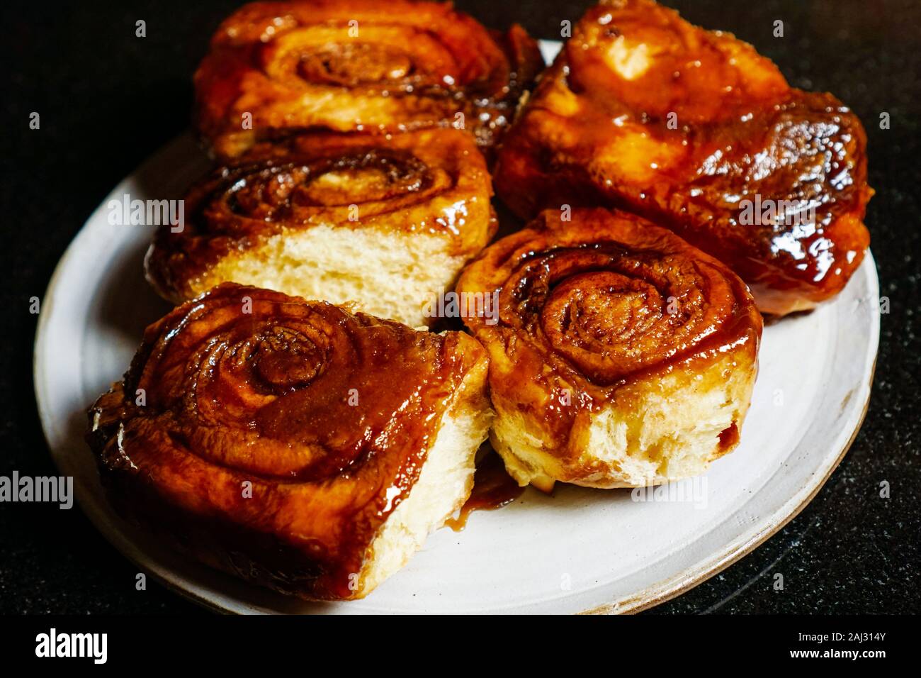 Five homemade sticky buns with dark background Stock Photo