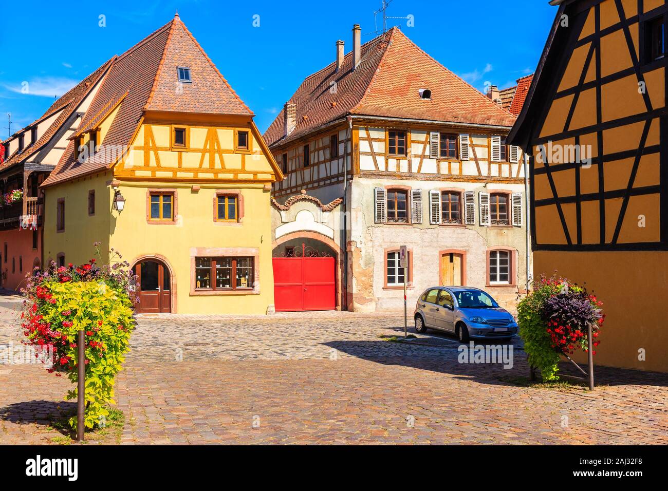 Beautiful facades of houses decorated with flowers on square of