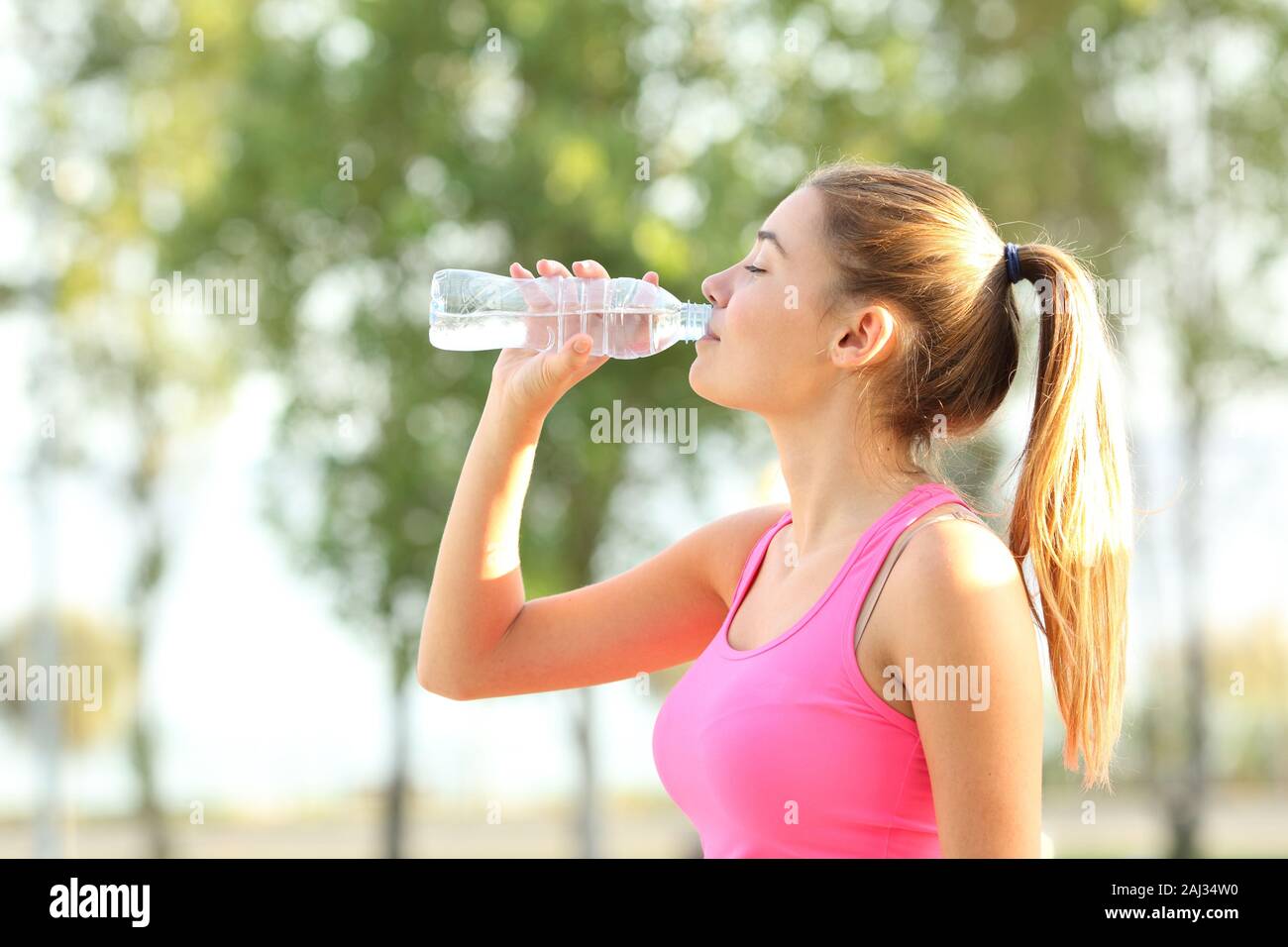 Profile of a dehydrated runner hidrating drinking bottled water in a