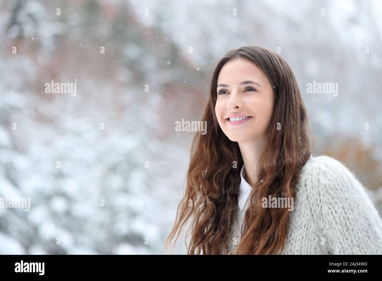Candid beautiful teen watching snow in the mountain in winter Stock Photo
