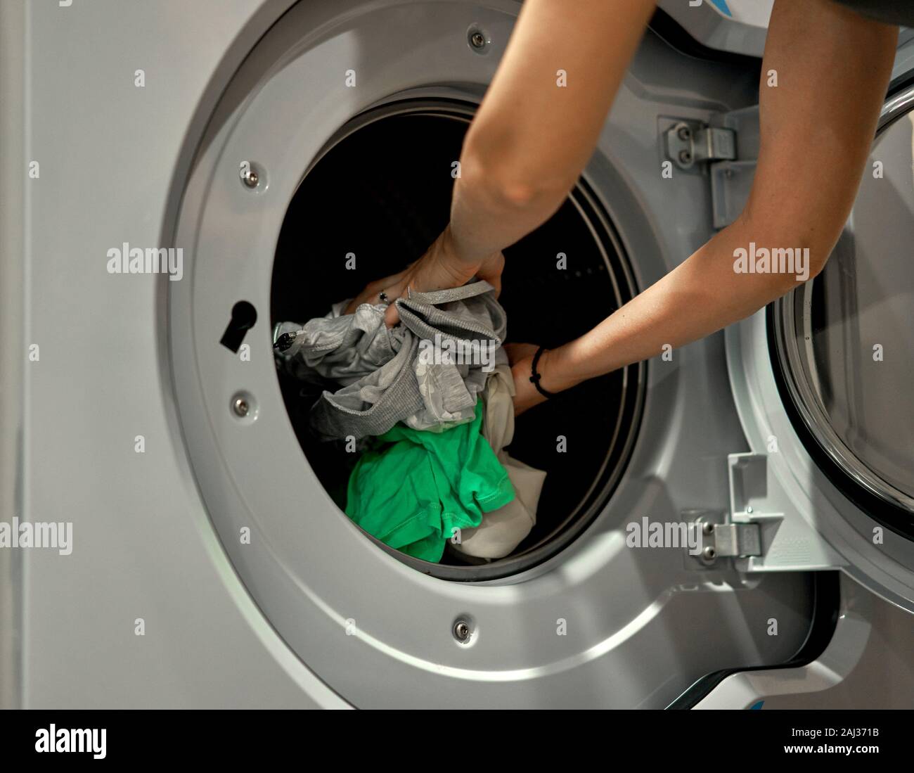 girl puts things in the washing machine Stock Photo Alamy