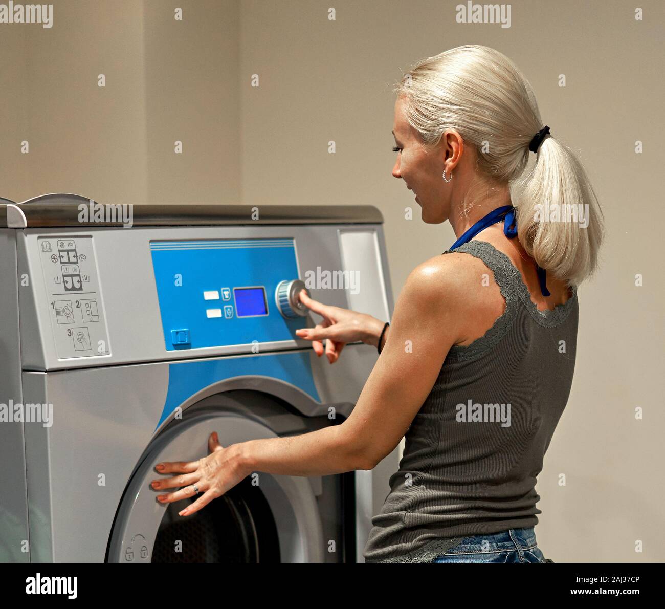 girl puts things in the washing machine Stock Photo - Alamy