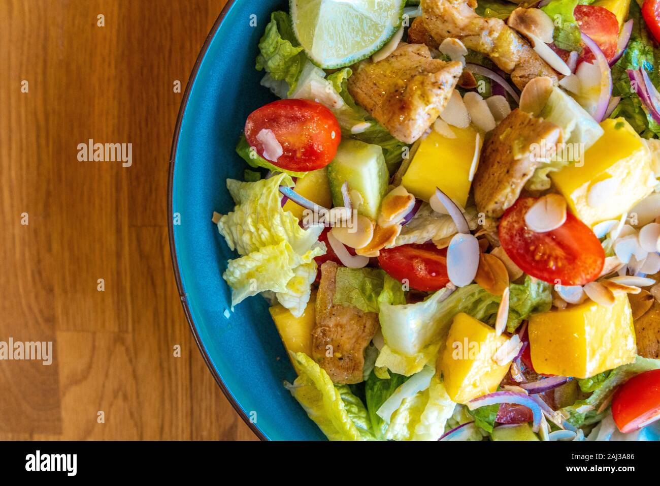Top view of a homemade chicken salad with mango, tomatoes and fresh onion Stock Photo