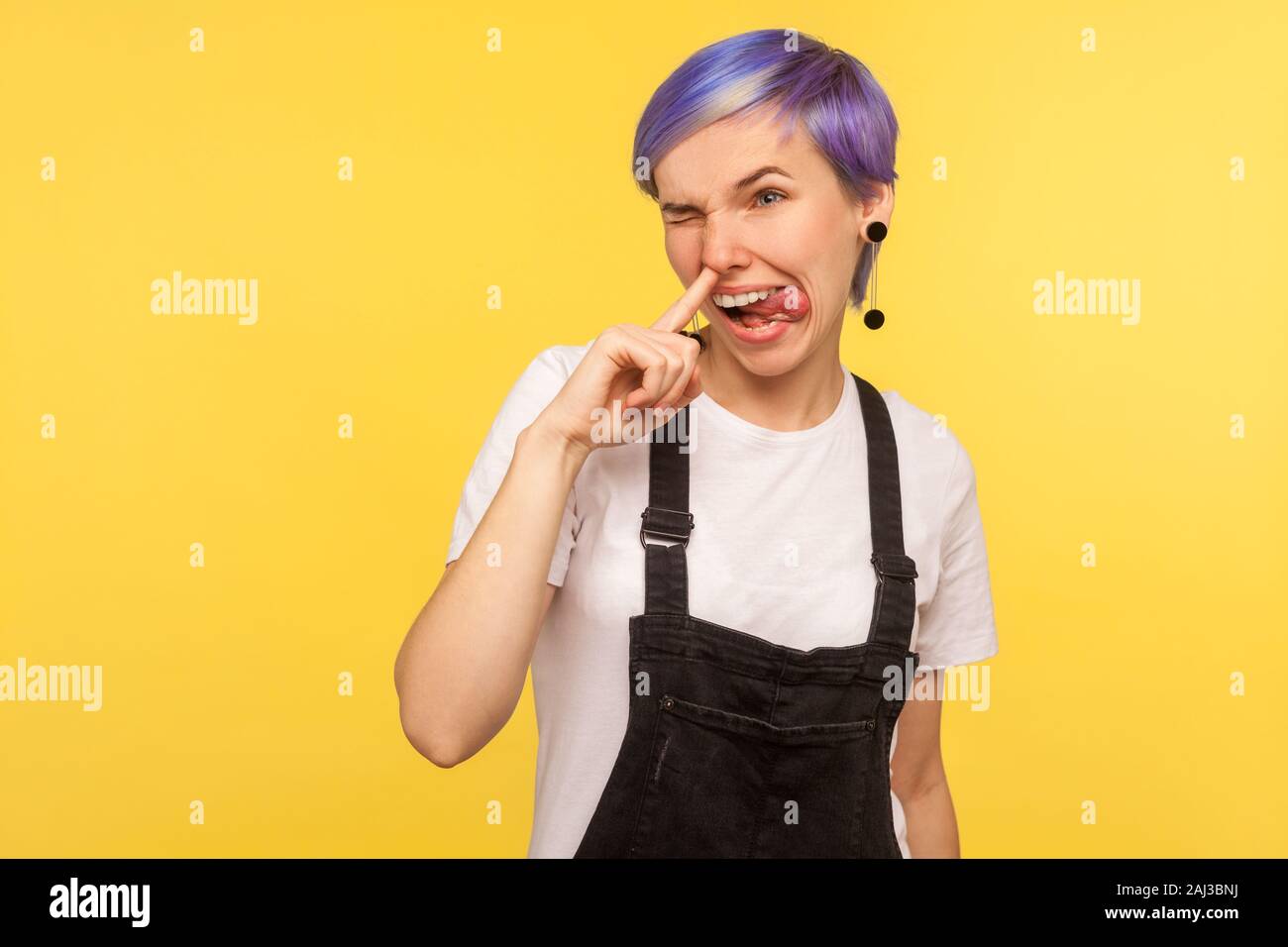 Portrait of funny impolite hipster girl with violet short hair in denim