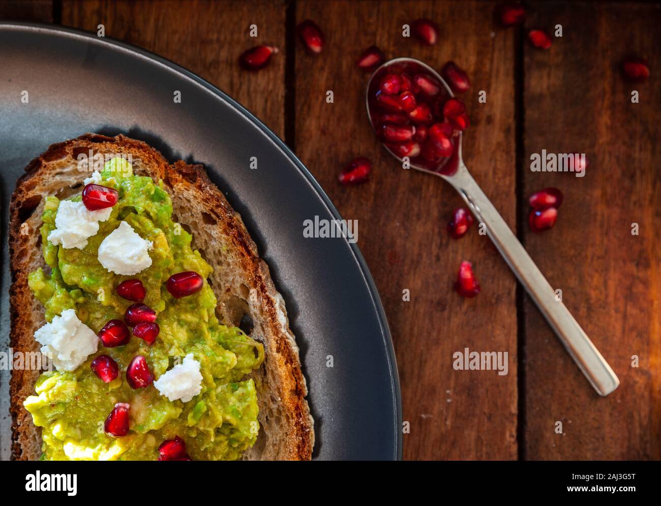 Avocado sandwich on sliced bread toast made with pomegranate and feta cheese Stock Photo