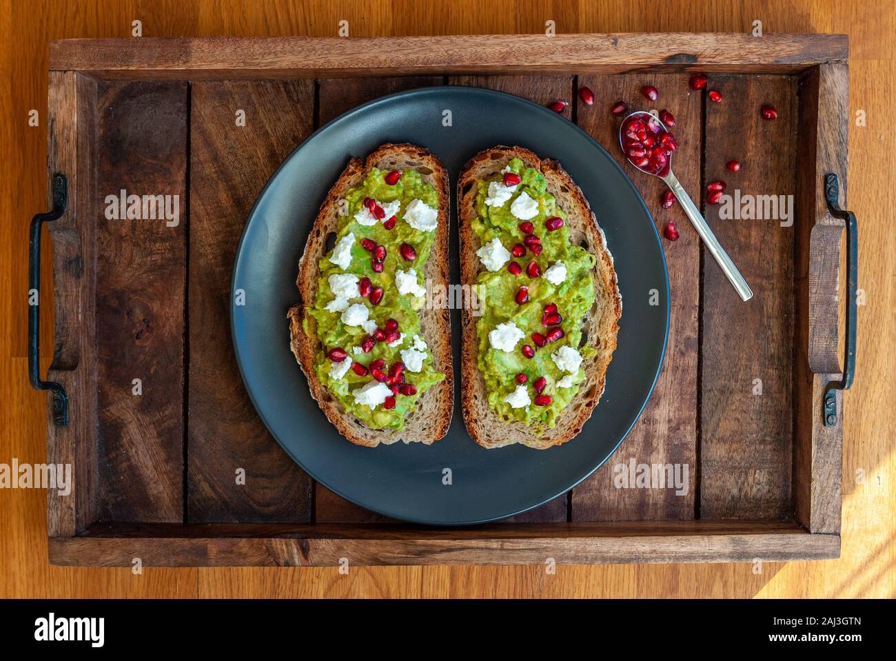 Avocado sandwich on sliced bread toast made with pomegranate and feta cheese Stock Photo