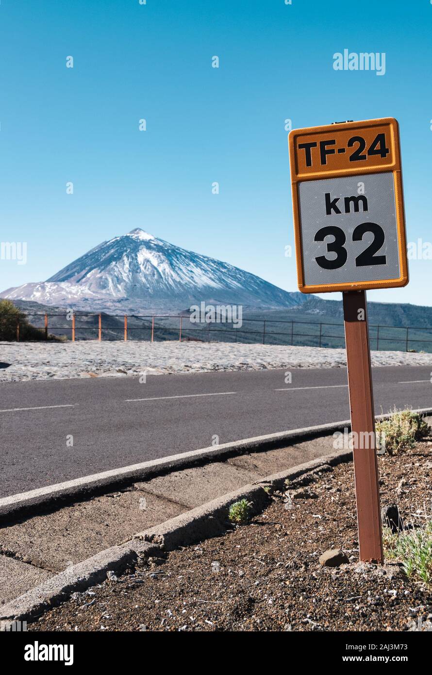 Tenerife,Spain - December 19, 2019: Km 32 of TF-24 road sign in Teide National Park on Tenerife with a parked car and Mount Teide in the background. Stock Photo