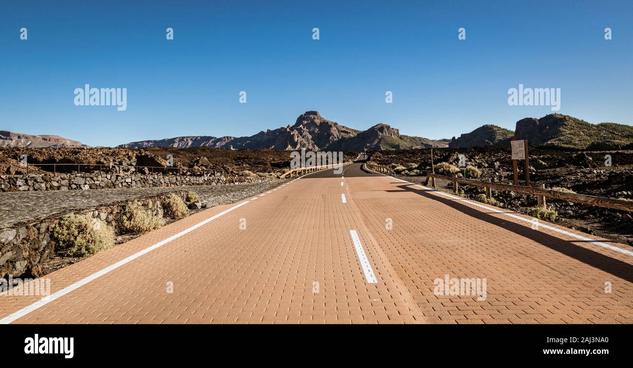 Empty road running through volcanic, rocky desert in Teide National Park, Tenerife, Spain. Stock Photo