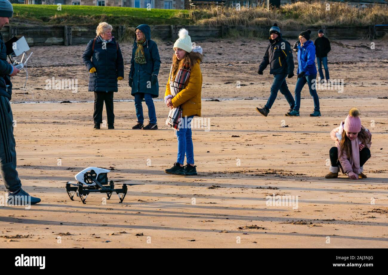 A man flying a drone illegally within a crowd of people on the beach, West Beach, North Berwick, East Lothian, Scotland, UK Stock Photo