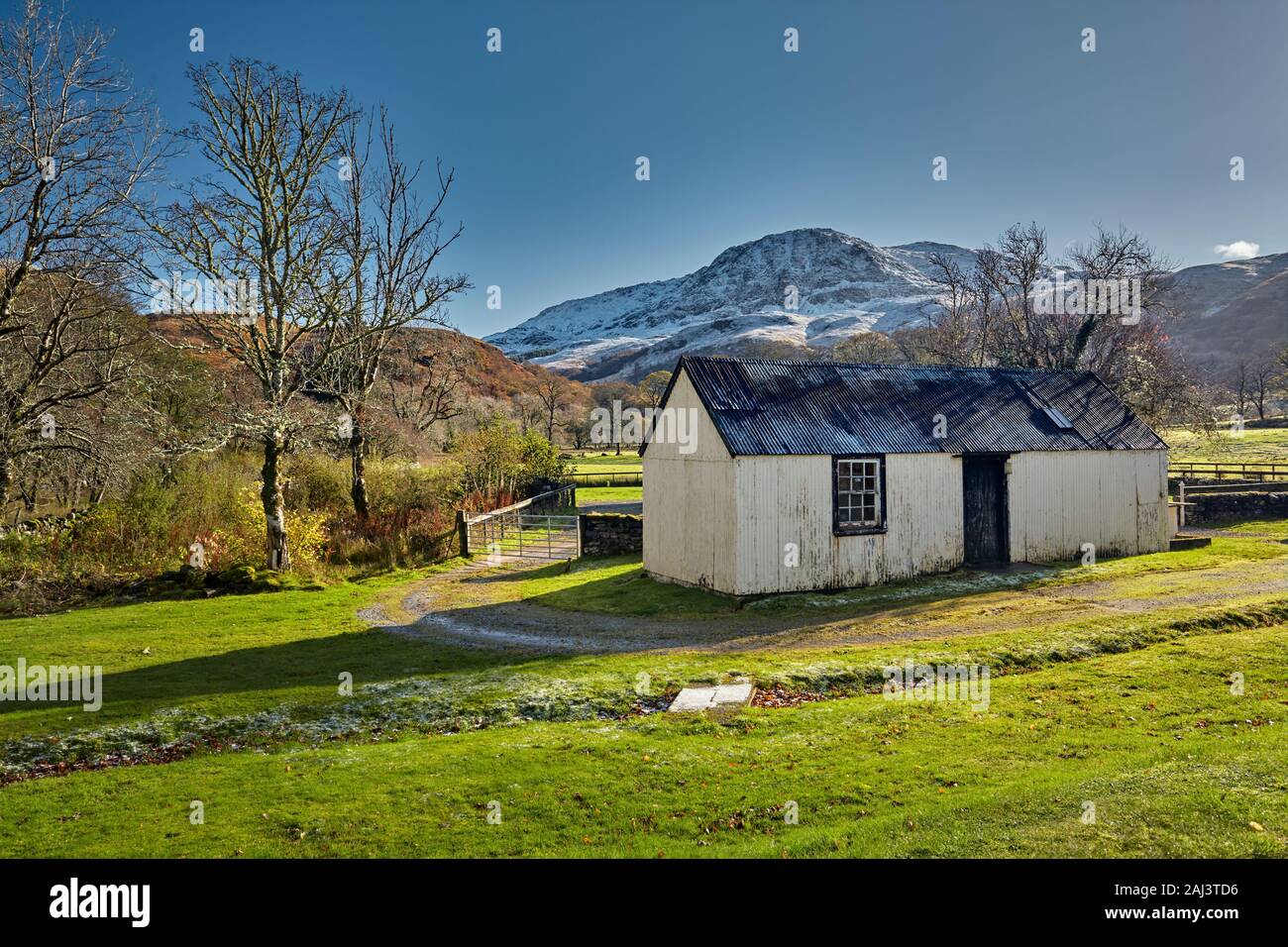 Corrugated iron croft in Eilanreach, Kyle with a Highland view backdrop and early autumn snow, Scotland Stock Photo