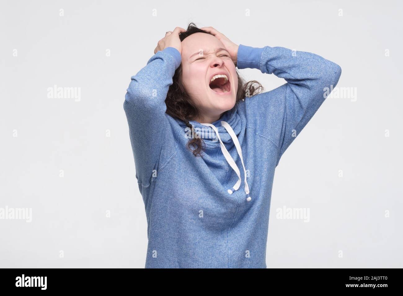 Devastated female student screams desperately, being angry as fails exam, being irritated and aggressive. Furious woman yells loudly. Negative facial Stock Photo